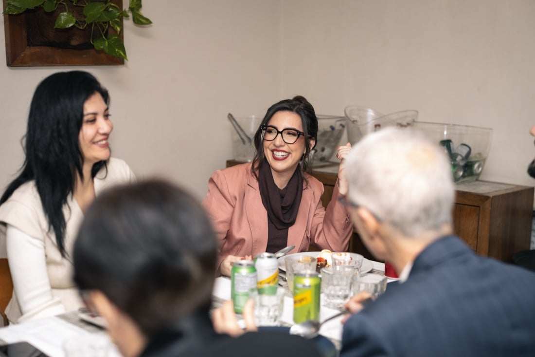 Lilian Cidreira rindo à mesa, em conversa com os convidados